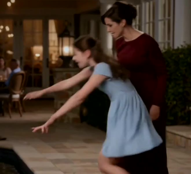 Lily reaches for the necklace as Vivian moves behind her